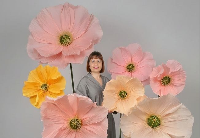 Flores de papel gigantes en tonos rosa y verde agrupadas en un ramo, diseño de Cartoncita
