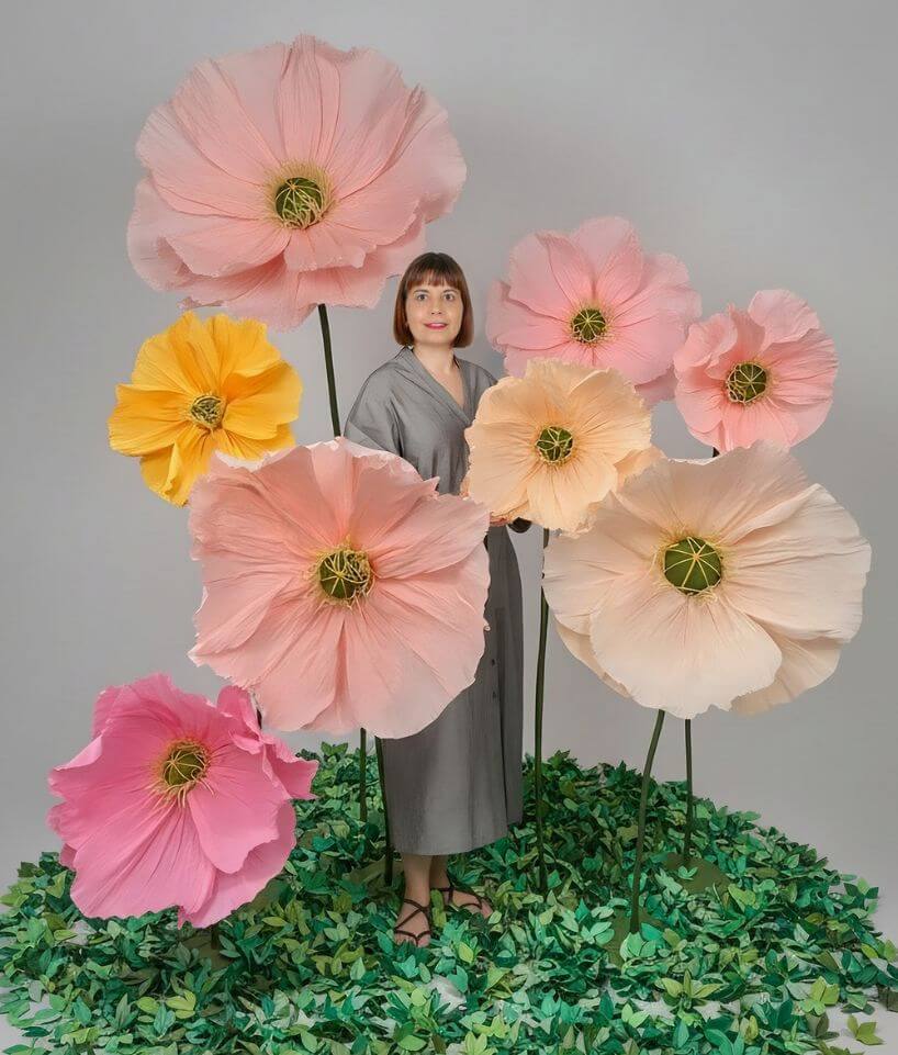 Ramo de flores gigantes de papel en tonos pastel con tallos largos sobre fondo neutro, creado por Cartoncita